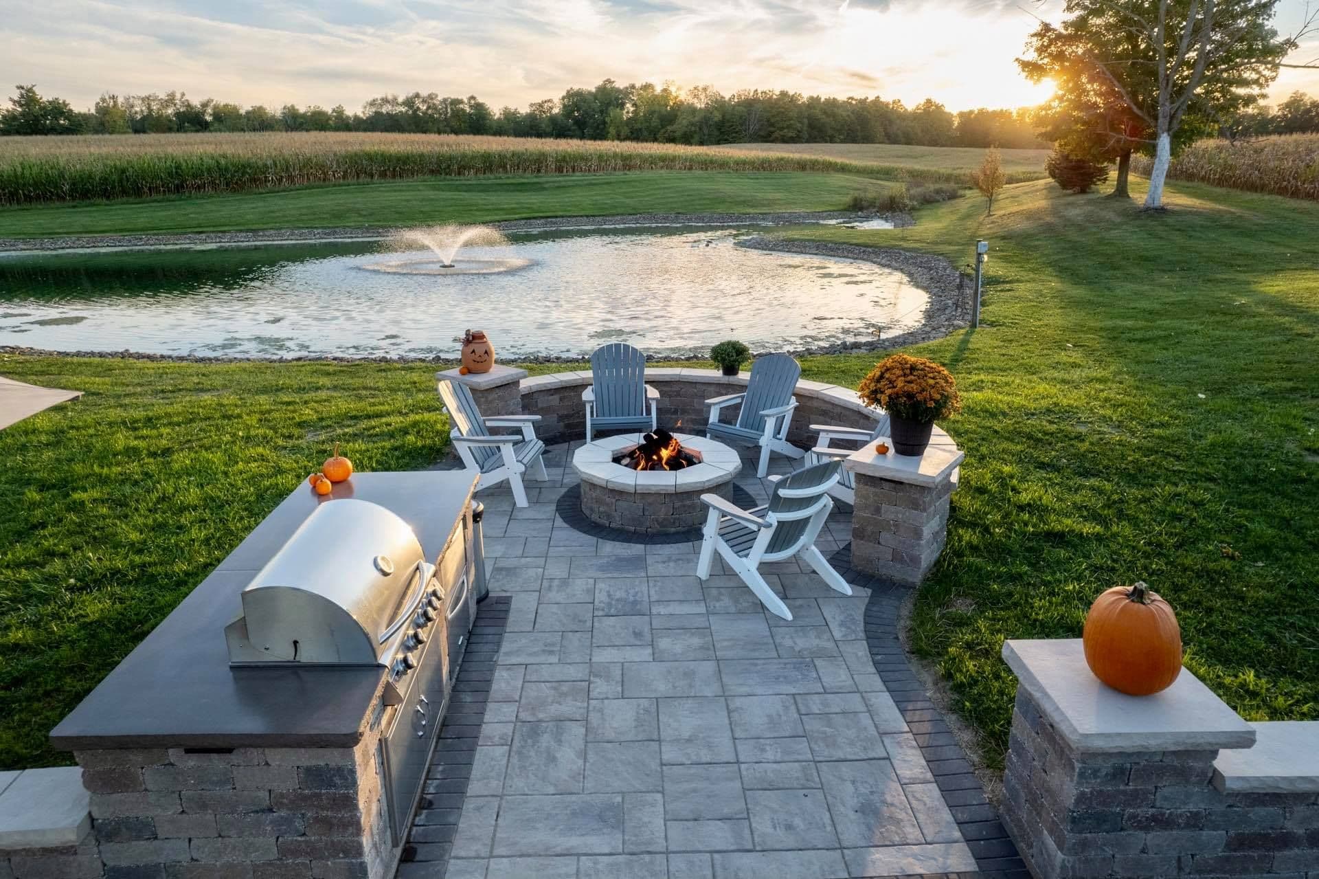 Landscape design and installation project featuring a pond, patio, fire pit, built-in grill, and more.